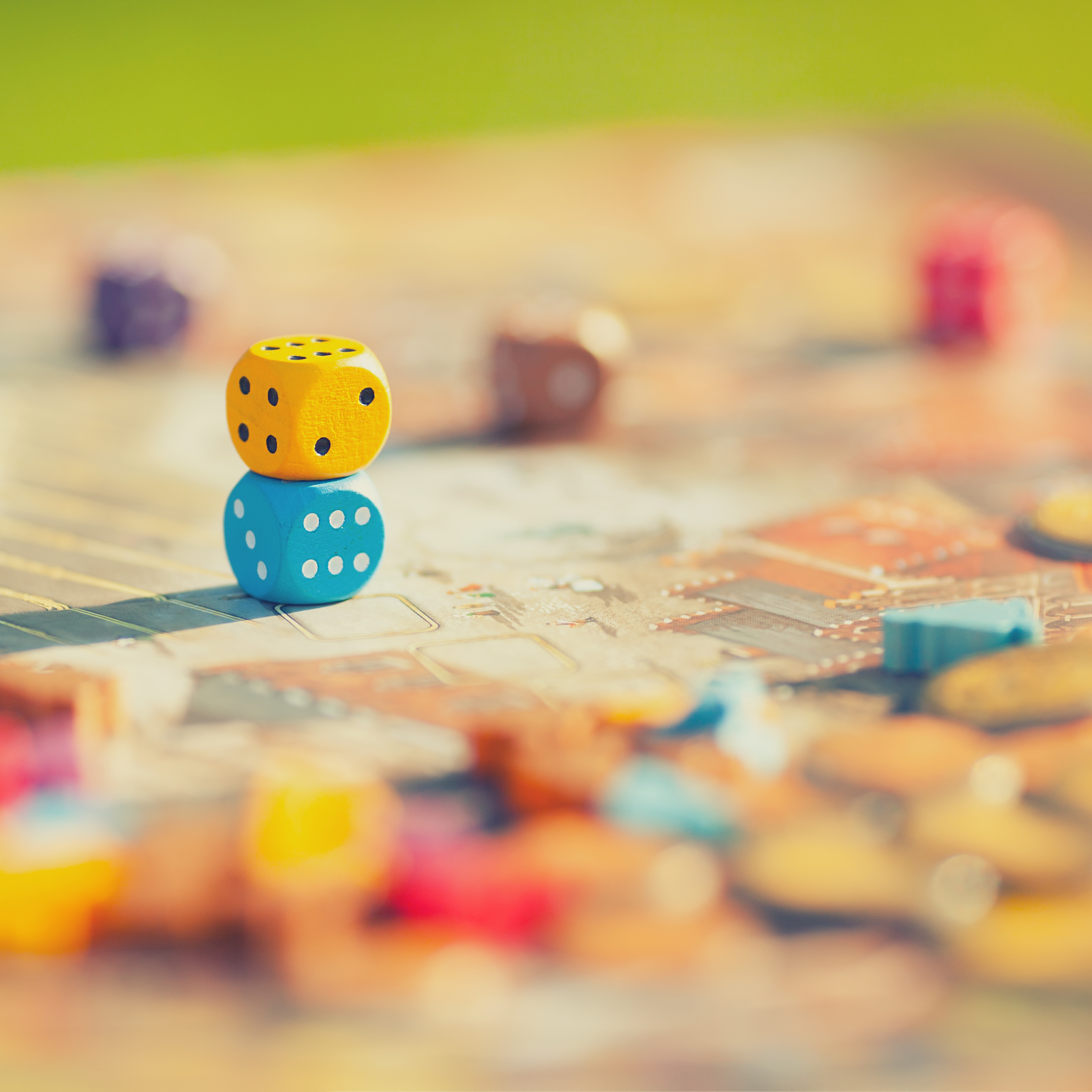 Games default image: photo of a board game with multicolored dice and pieces. The edges of the photo are aesthetic and blurry.
