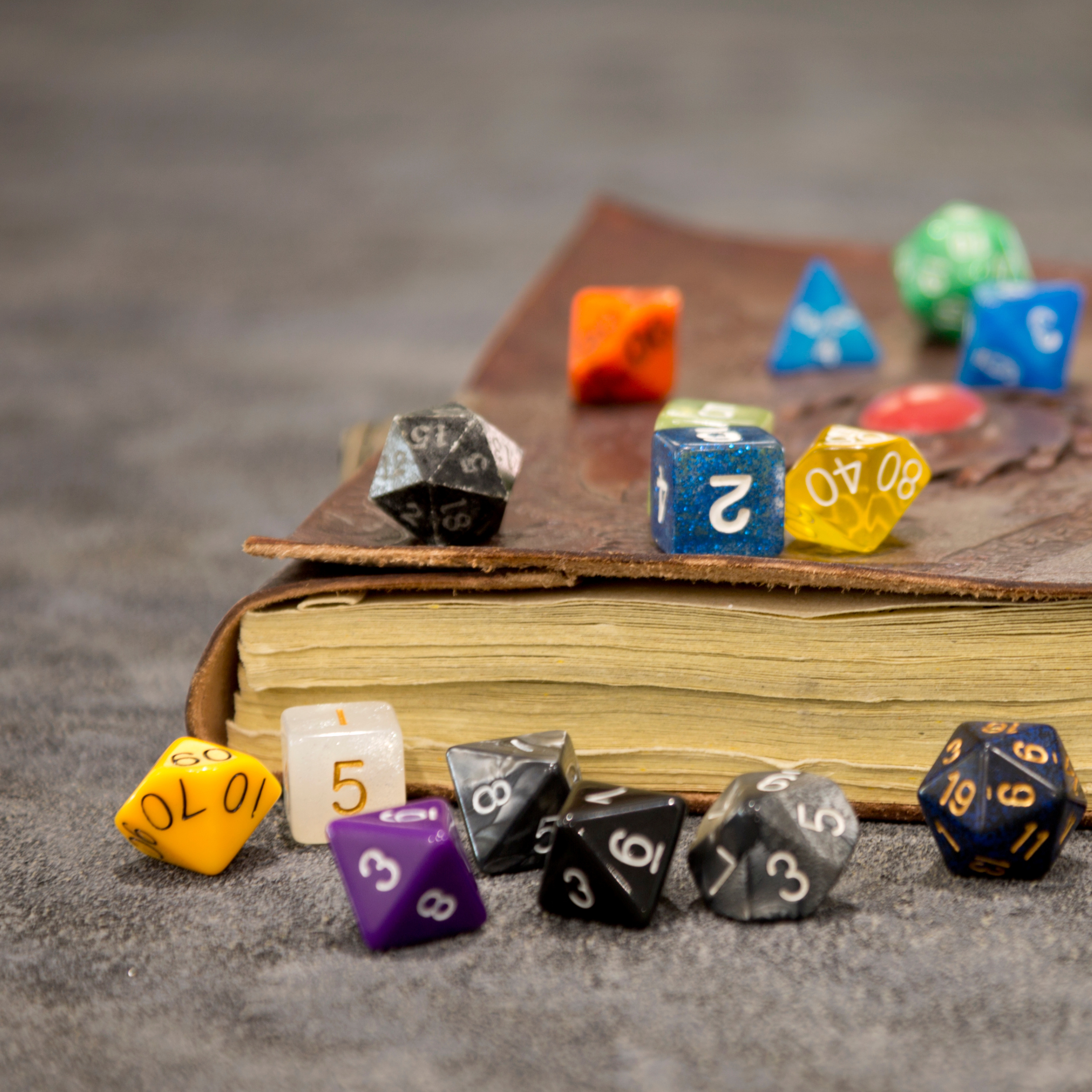 Tabletop role playing game supplies. Notebook and several dice with different quantities of sides and colors