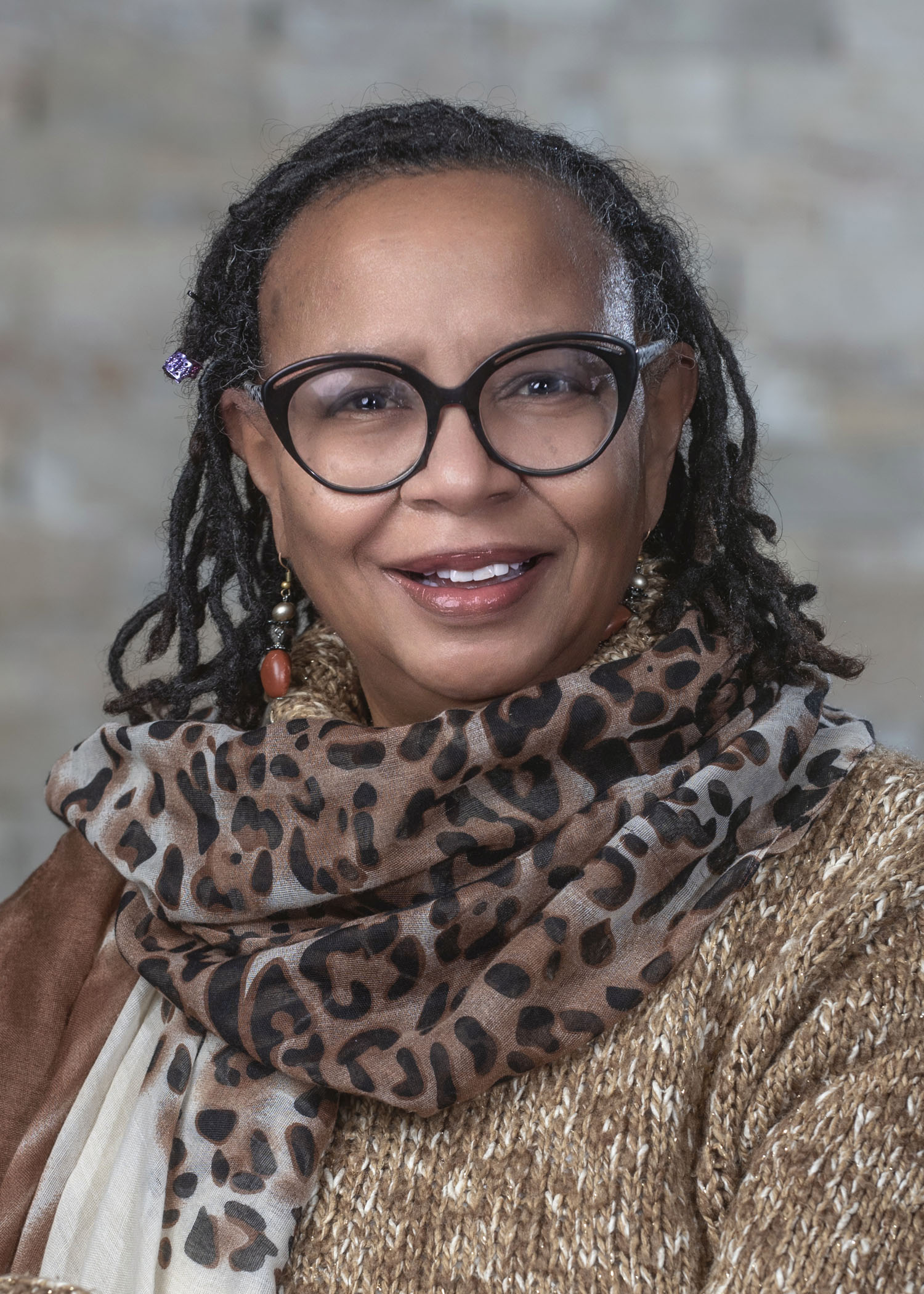 Zelmon "Zee" Johnson, a Black woman wearing glasses and a cheetah-print scarf
