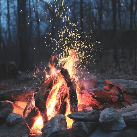 An evening campfire with sparks floating upwards