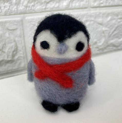 Small gray, black and white standing felted baby penguin with a red scarf