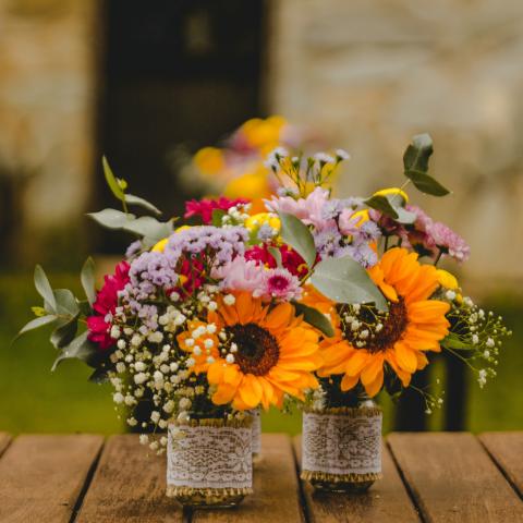 Small flower arrangements with sunflowers, baby's breath, carnations, and more