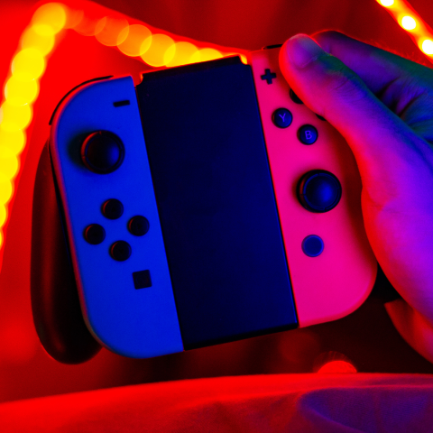 A pair of Nintendo Switch controllers, backlit by glowing yellow lights