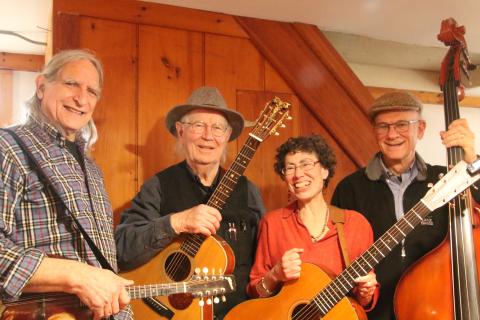 Four musicians posed with string instruments