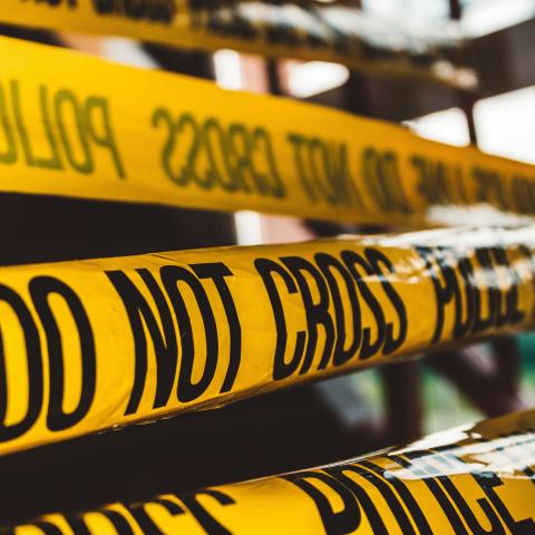 Crime scene blocked by yellow police tape that says "do not cross"