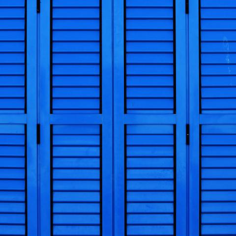 Rows of blue window shutters that kind of look like the Jeopardy game board