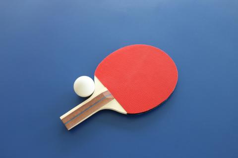 red ping pong paddle on a blue background