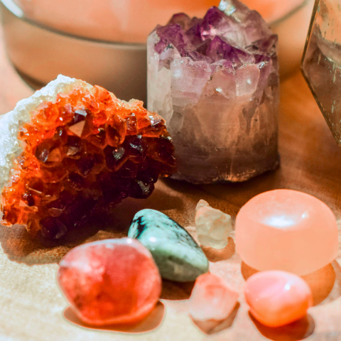 A selection of various colored stones and crystals on a cream tablecloth