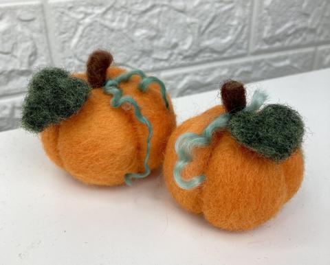 Felted pumpkin on white table