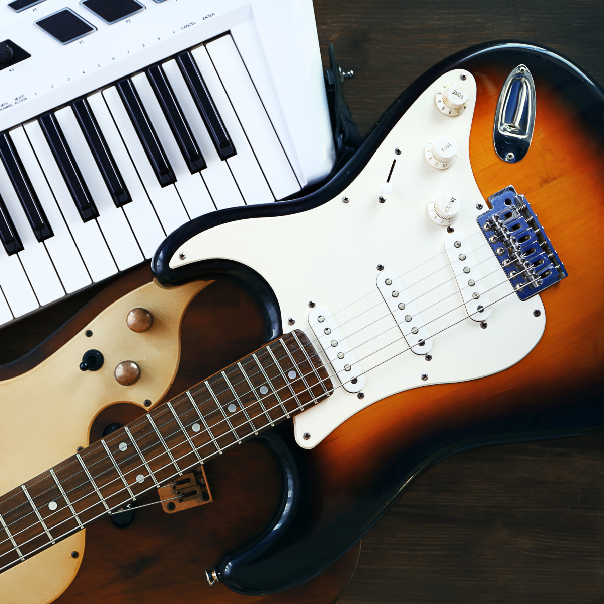 Two electric guitars and a white keytar