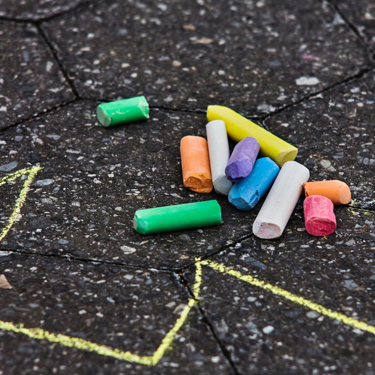 Colorful pieces of chalk laying on a patio