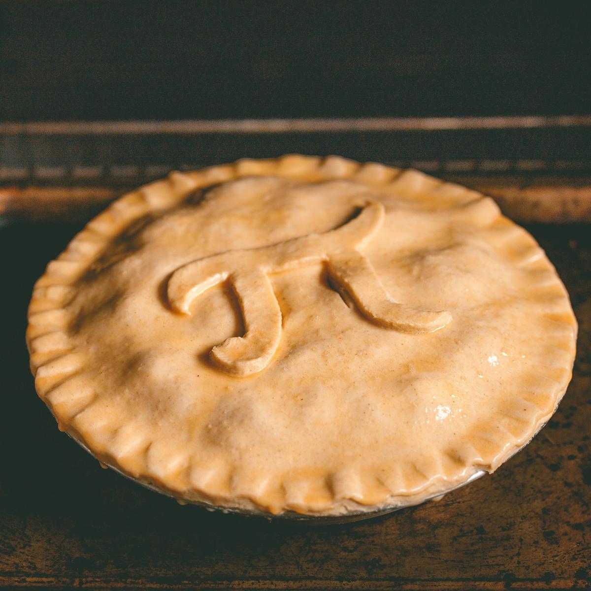 A pie in the oven, with the mathematical symbol for pi atop its crust