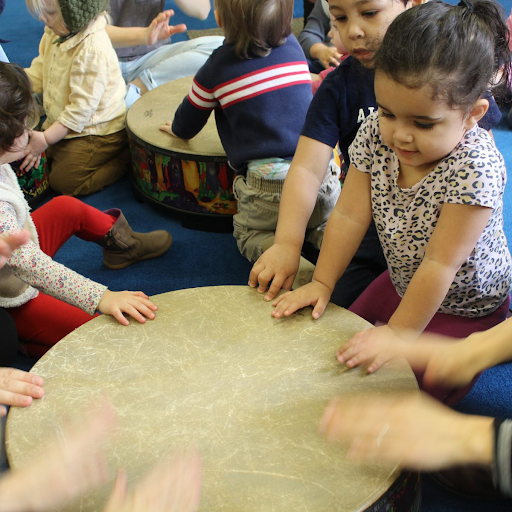 Photograph of young children interacting with a large drum.