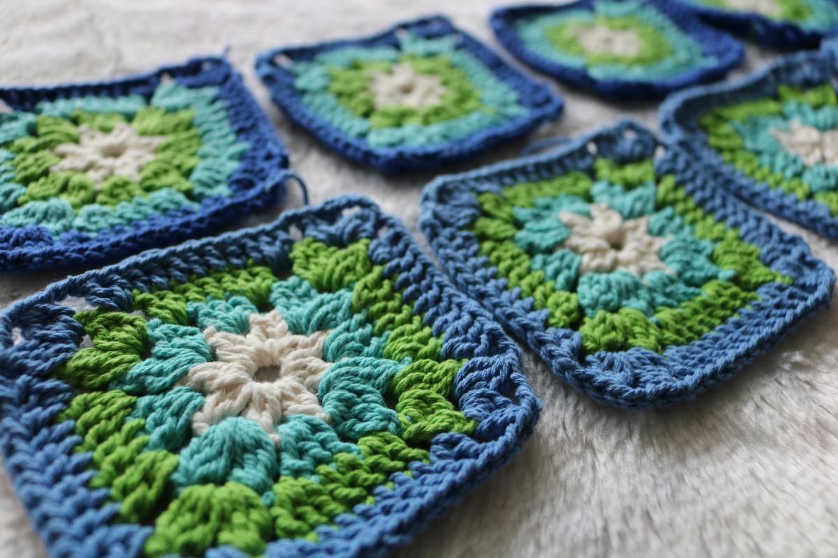 Crocheted granny squares in blue, green, and white